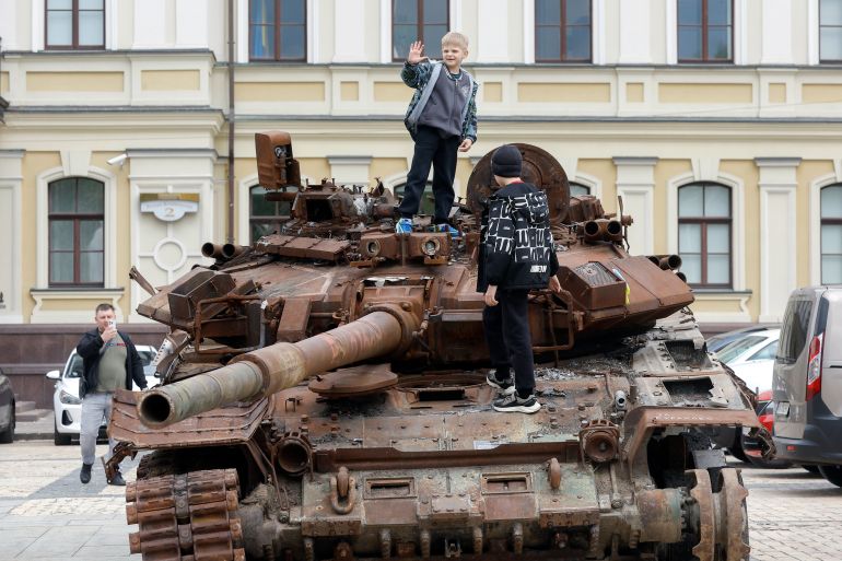 epa12102661 Ukrainian boys climb atop a destroyed tank displayed at an open-air exhibition of seized Russian military machinery in downtown Kyiv, Ukraine, 15 May 2025, amid the Russian invasion. Ukrainians mark Vyshyvanka Day annually on the third Thursday of May, a holiday dedicated to vyshyvanka, a traditional embroidered shirt that features elements of Ukrainian ethnic embroidery. EPA-EFE/SERGEY DOLZHENKO