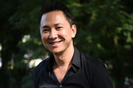 A portrait of Viet Thanh Nguyen against a leafy background.