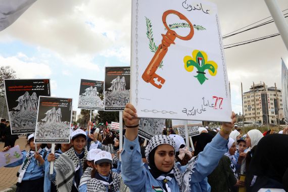Palestinians carry posters during a rally.