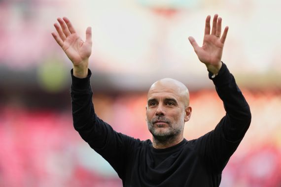 Manchester City's head coach Pep Guardiola waves to the fans