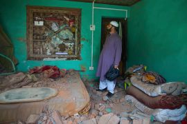 Kashmiri villager inspects his damaged house in Uri