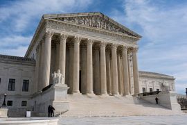 The US Supreme Court building, seen on a cloudy, blue-sky day.