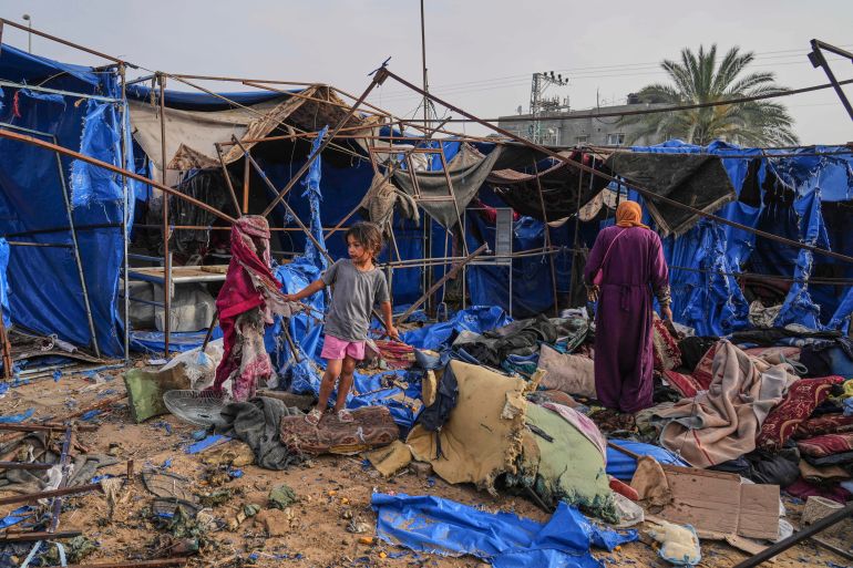 Palestinians inspect the damage caused by an Israeli airstrike that struck tents at Al-Aqsa Hospital in Deir al-Balah [Abdel Kareem Hana/AP Photo]