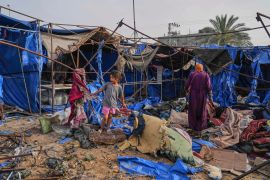 Palestinians inspect the damage caused by an Israeli airstrike that struck tents at Al-Aqsa Hospital in Deir al-Balah [Abdel Kareem Hana/AP Photo]