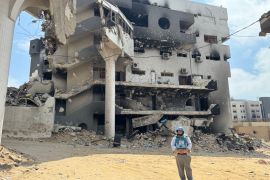 A man in front of a burned hospital building